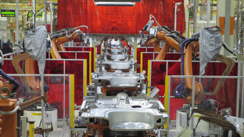 Automated car bodyside welding line integration featuring KUKA robotic arms in a car manufacturing plant.