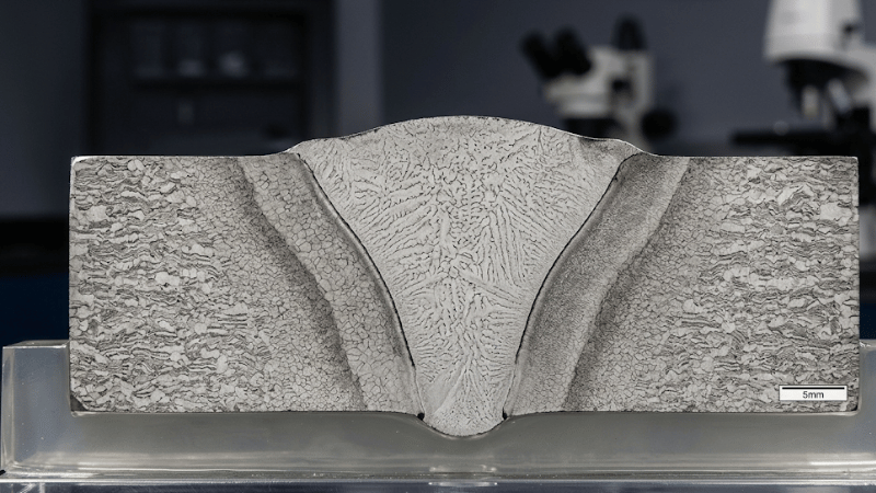 Close-up of a welded steel joint cross-section showing the weld bead and heat-affected zone
