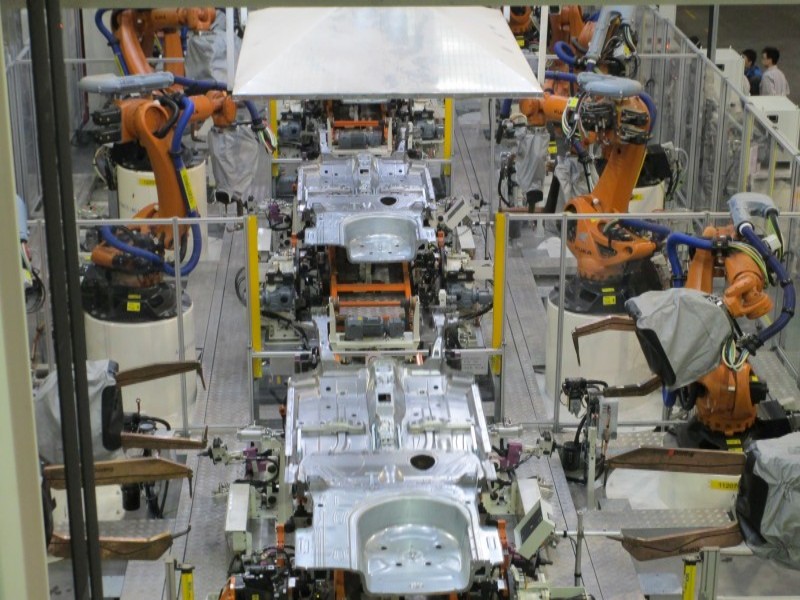 High-speed robotic spot welding integration for efficient car chassis side panel assembly.